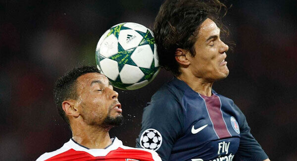 Arsenal's Francis Coquelin and PSG's Edinson Cavani battle for a high ball at the Parc des Princes. AP Photo/Christophe Ena