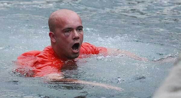 The man who was set upon by others, swims to shore after they threw him in to the harbour. Photo: Niall Carson/PA