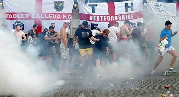 French police fire tear gas as they clash with English football fans at The Queen Victoria pub in Marseille ahead of the first game in Euro 2016. Photo: Niall Carson/PA