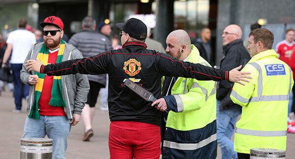 Stewards search fans in a security check before the Barclays Premier League match at Old Trafford. Photo: Martin Rickett/PA