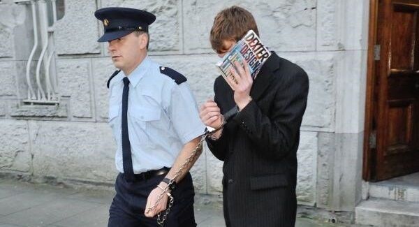 File photo of Adam Heneghan being escorted by a Garda from Cork Circuit Criminal Court.