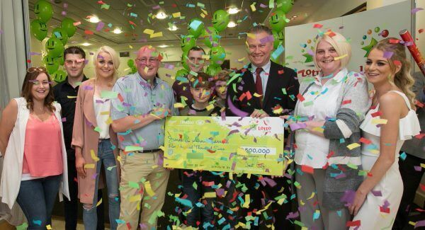 The Carroll family from Kildare (left to right) Zoe, Darren, Shannon James, John, James Jnr, Fintan, Irish National Lottery CEO Dermot Griffin, Ann and Nicole after collecting their €500,000 today. Pic: Gareth Chaney/Collins