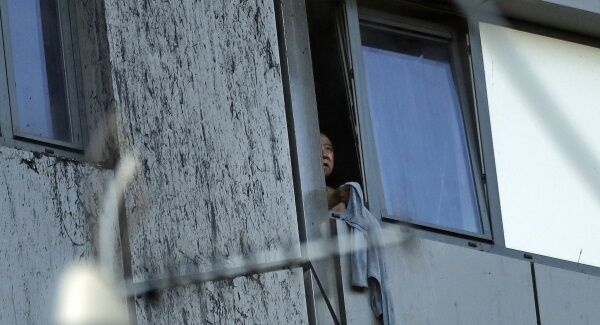 A person peers out of a window from the building on fire in London. Pic: PA A person peers out of a window from the building on fire in London. Pic: PA