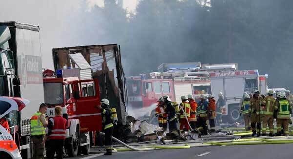 Rescue workers stand beside burnt-out coach on the motorway A9 near Muenchberg, southeastern Germany, Monday, July 3, 2017 after a bus crashed into a truck and caught fire.. AP.