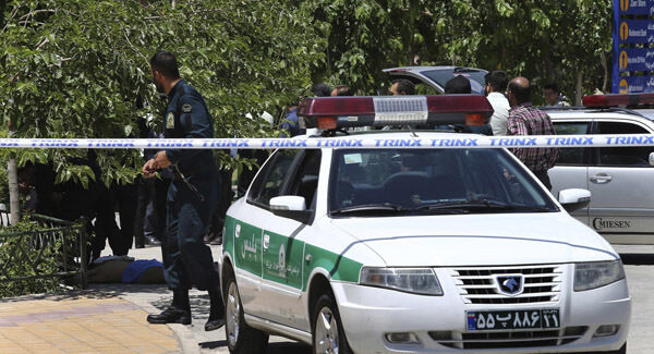 The body of a terrorist, at background left, lies on the ground while police control the scene at the shine of late Iranian revolutionary founder Ayatollah Khomeini, just outside Tehran, Iran, Wednesday. Picture AP