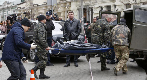 Forensic experts carry the body of Denis Voronenkov. AP Photo.