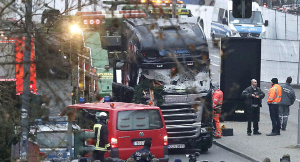 People stand near a truck which ran into a crowded Christmas market killing several people yesterday evening in Berlin. Pictures: AP People stand near a truck which ran into a crowded Christmas market killing several people yesterday evening in Berlin. Pictures: AP