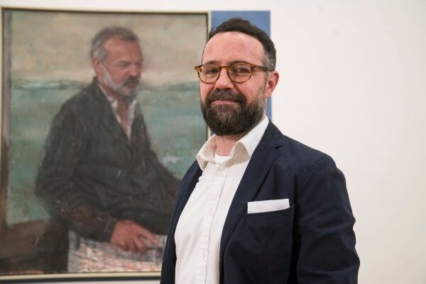 Artist Gareth Reid with the portrait of Graham Norton. Artist Gareth Reid with the portrait of Graham Norton.