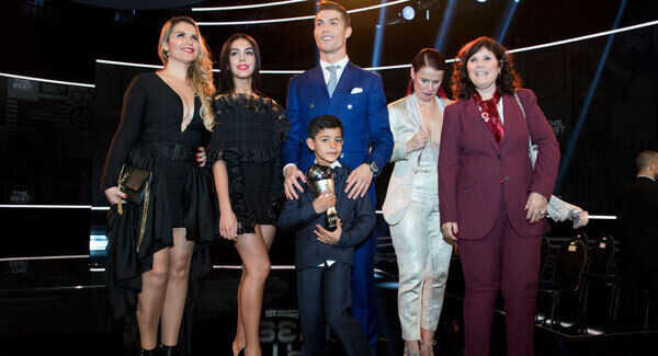 Cristiano Ronaldo Junior holds the trophy his father Cristiano Ronaldo won for The Best FIFA Men's Player award as they pose for a photo with Ronaldo's girlfriend Georgina Rodriguez, second left, and his mother Maria Dolores dos Santos Aveiro, right, and others. Ennio Leanza/Keystone via AP Cristiano Ronaldo Junior holds the trophy his father Cristiano Ronaldo won for The Best FIFA Men's Player award as they pose for a photo with Ronaldo's girlfriend Georgina Rodriguez, second left, and his mother Maria Dolores dos Santos Aveiro, right, and others. Ennio Leanza/Keystone via AP