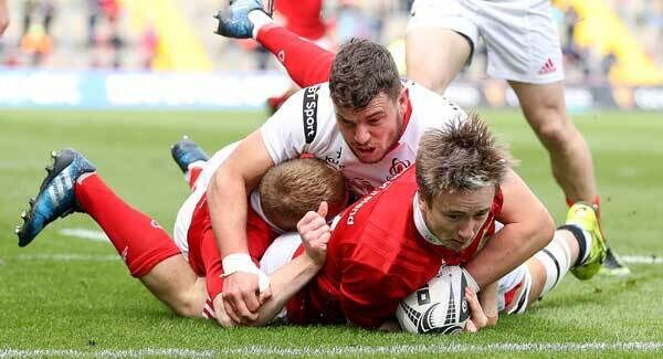 Munster's Angus Lloyd scores a try despite the efforts of Ulster’s Sean Reidy. Pic: INPHO/Tommy Dickson