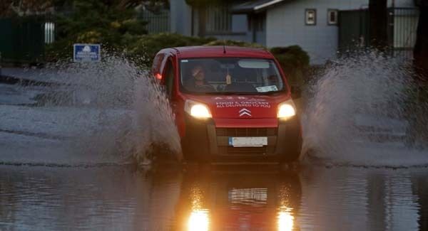 A motorist powers through flood water on Cork's newly opened Centre Park Road. Picture: Jim Coughlan