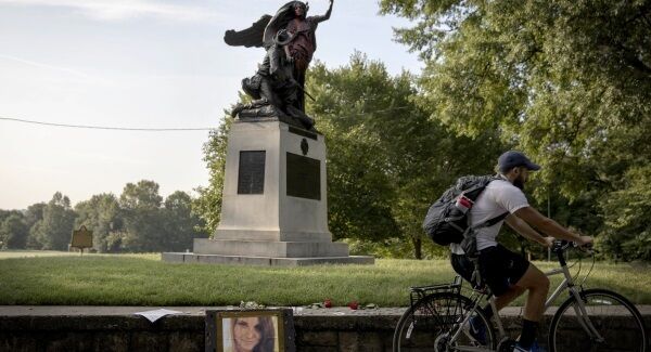 A photo of victim Heather Heyer sits beneath a statue depicting a Confederate soldier in Piedmont Park in Atlanta that was vandalized with spray paint from protesters who marched through the city last night to protest the weekend violence in Charlottesville, Virginia.