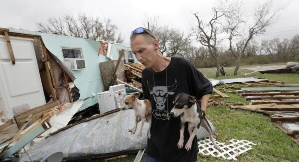 Sam Speights holds two of his dogs as he checks on the damage to his home in the wake of Hurricane Harvey, yesterday. Sam Speights holds two of his dogs as he checks on the damage to his home in the wake of Hurricane Harvey, yesterday.