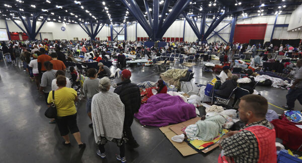 People line up for food as others rest at the George R. Brown Convention Centre in Houston. Picture: AP People line up for food as others rest at the George R. Brown Convention Centre in Houston. Picture: AP