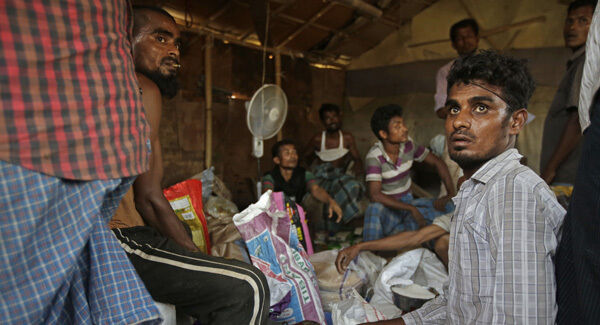 Rohingya refugees distributes food items, donated by locals, among other refugees at a camp for the refugees in New Delhi, India.