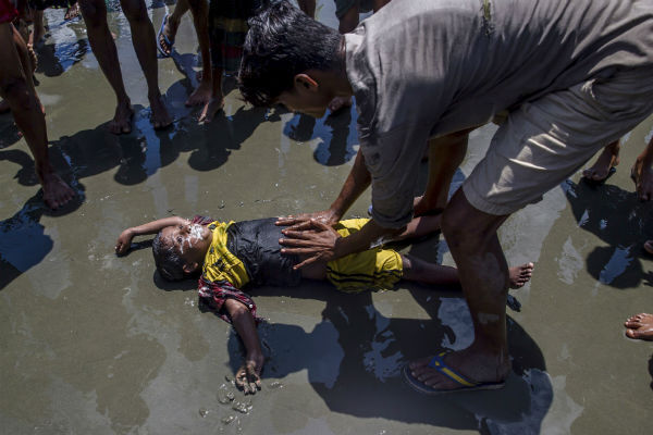A Rohingya Muslim boy froths from the mouth as a man successfully tries to revive him after the boat he was traveling in capsized just before reaching shore at Shah Porir Dwip, Bangladesh on September 14, 2017. AP Photo/Dar Yasin A Rohingya Muslim boy froths from the mouth as a man successfully tries to revive him after the boat he was traveling in capsized just before reaching shore at Shah Porir Dwip, Bangladesh on September 14, 2017. AP Photo/Dar Yasin