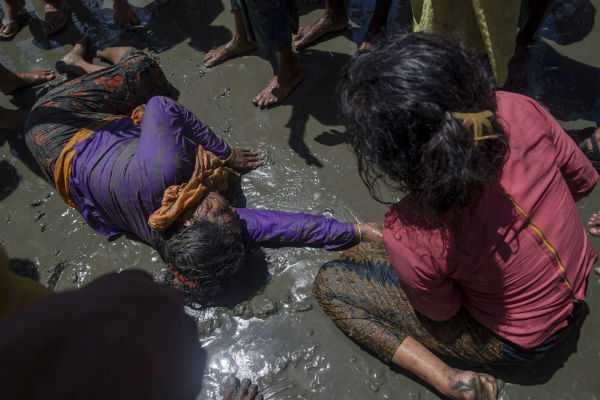 A Rohingya Muslim woman, who crossed over from Burma into Bangladesh, lies unconscious on the shore of Bay of Bangal after the boat she was traveling in capsized at Shah Porir Dwip, Bangladesh. AP Photo/Dar Yasin A Rohingya Muslim woman, who crossed over from Burma into Bangladesh, lies unconscious on the shore of Bay of Bangal after the boat she was traveling in capsized at Shah Porir Dwip, Bangladesh. AP Photo/Dar Yasin