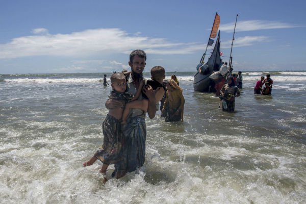 A Rohingya Muslim man walks to shore carrying two children after they arrived on a boat from Burma to Bangladesh in Shah Porir Dwip, Bangladesh. AP Photo/Dar Yasin A Rohingya Muslim man walks to shore carrying two children after they arrived on a boat from Burma to Bangladesh in Shah Porir Dwip, Bangladesh. AP Photo/Dar Yasin