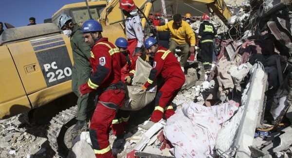 Rescuers carry away the body of an earthquake victim in Sarpol-e-Zahab in western Iran