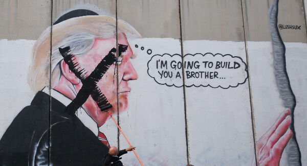 A Palestinian paints over a mural of the U.S. President Donald Trump during a protest in Bethlehem. Picture: AP Photo/Nasser Shiyoukhi A Palestinian paints over a mural of the U.S. President Donald Trump during a protest in Bethlehem. Picture: AP Photo/Nasser Shiyoukhi