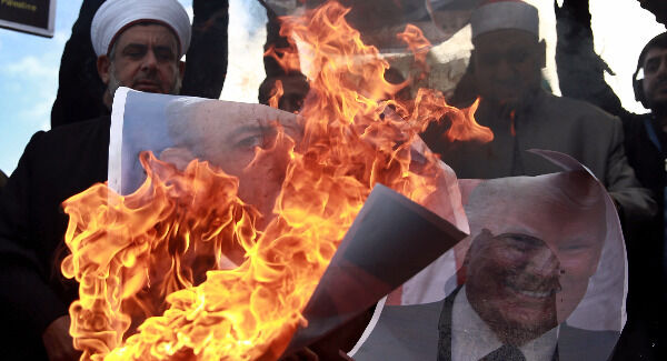 Palestinians burn posters of Israeli Prime Minister Benjamin Netanyahu and U.S. President Donald Trump in Gaza City. Picture: AP Photo/ Khalil Hamra Palestinians burn posters of Israeli Prime Minister Benjamin Netanyahu and U.S. President Donald Trump in Gaza City. Picture: AP Photo/ Khalil Hamra