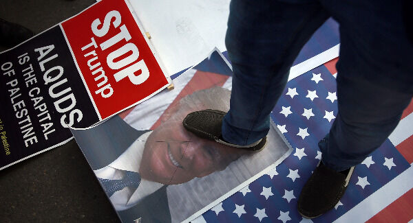 A Palestinian steps on a poster of U.S. President Donald Trump and a representation of the American flag during a protest. Picture: AP Photo/ Khalil Hamra A Palestinian steps on a poster of U.S. President Donald Trump and a representation of the American flag during a protest. Picture: AP Photo/ Khalil Hamra
