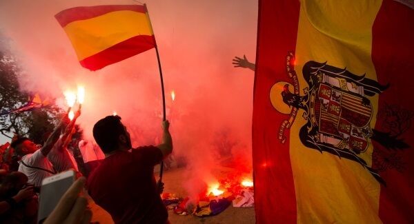 Extreme right-wing demonstrators hold pre-constitution Spanish flags as they burn esteladas or independence flags during an alternative celebration for Spain's "Dia de la Hispanidad", or Spain's National Day, in Barcelona. Extreme right-wing demonstrators hold pre-constitution Spanish flags as they burn esteladas or independence flags during an alternative celebration for Spain's "Dia de la Hispanidad", or Spain's National Day, in Barcelona.