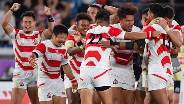 Japanese players celebrate beating Scotland to top their group.