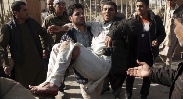 A wounded man is assisted at the site of a deadly suicide attack in the center of Kabul, Afghanistan.