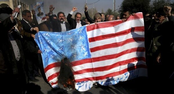 Iranian worshippers chant slogans while they burn a representation of U.S. flag during a rally against anti-government protestors after the Friday prayer ceremony in Tehran. Pic: AP Photo/Ebrahim Noroozi