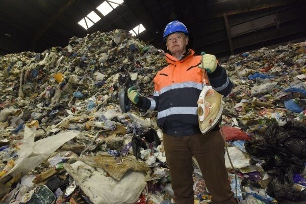 Des Crinion holding a side mirror from a car and an iron, just two of thousands of items that should not be in household recycling bags. Picture: Moya Nolan