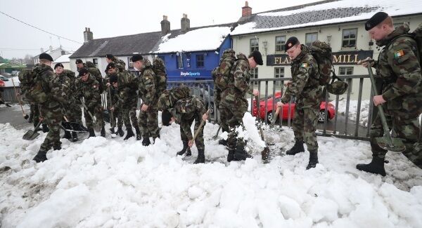 Members of the public and Defence forces cadets take part in a clean up of snow in Sallins Co Kildare. Photo: Niall Carson/PA Wire