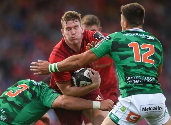 Chris Farrell of Munster is tackled by Simone Ferrari, left and Tommaso Benvenuti of Benetton.