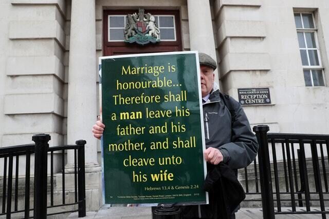 A man holds a placard quoting the Bible outside the Royal Courts of Justice in Belfast (Brian Lawless/PA)