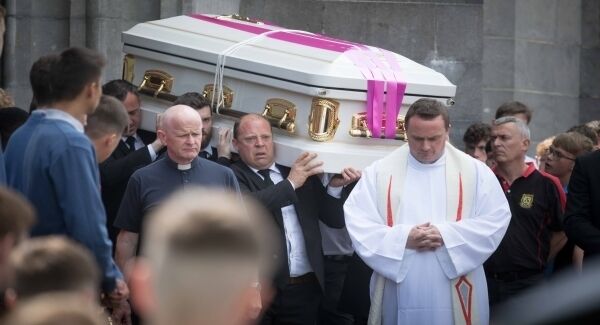 Mourners carry the coffin draped with a Munster flag as Ennis Rugby Club members provide a guard of honour at the funeral of Shay Moloney at Ennis Cathedral on Monday morning.Photograph by Eamon Ward.