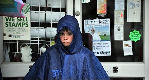 A young boy ponders in the rain as he waits for Pope Francis' arrival at Knock Shrine. Photo: Ray Ryan