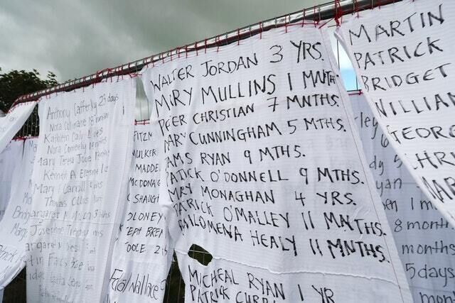 Hotel bedsheets with the names of hundreds of dead children draped on the gates of a mass burial site at Tuam, Co Galway (Niall Carson/PA)