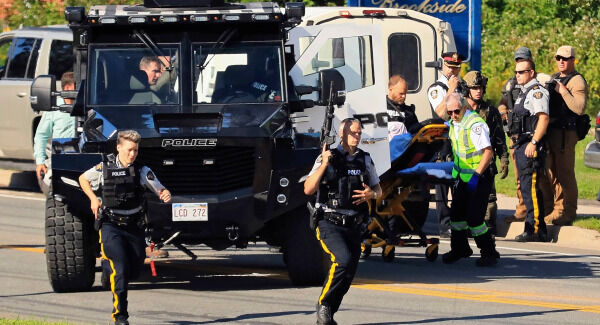 Police and RCMP officers survey the area of a shooting in Fredericton, New Brunswick, Canada. Pic: Keith Minchin/The Canadian Press via AP