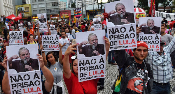 Supporters of Brazil's former President Luiz Inacio Lula da Silva hold up signs with a message that reads in Portuguese: "No to prison for Lula" in a protest on Friday. Photo: AP Photo/Denis Ferreira