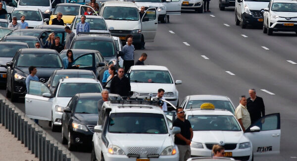 People stand still by their cars on a free way as a two-minute silence in memory of victims of the Holocaust in Tel Aviv. Photo: AP Photo/Ariel Schalit.