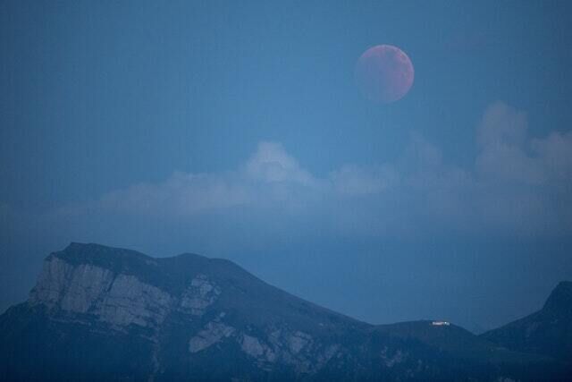 The moon turns red as seen from Lucerne, Switzerland (Urs Flueeler/PA)