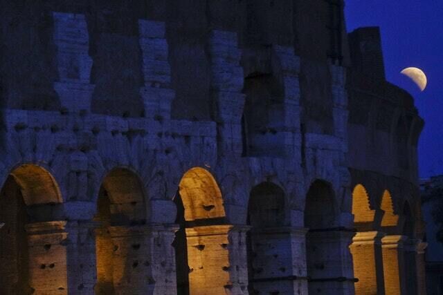 The moon rises past the Colosseum in Rome (Gregorio Borgia/AP)
