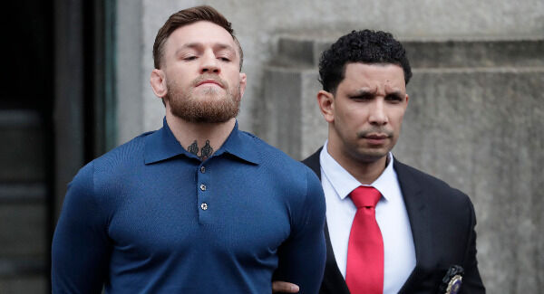 Conor McGregor is led by an official to an unmarked vehicle while leaving the 78th Precinct of the New York Police Department. Photo: AP Photo/Julio Cortez
