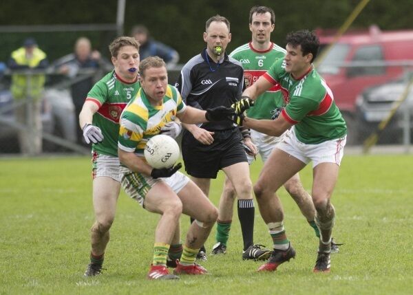 Carbery Rangers John Hayes is unfazed by Clonalkilty players Liam O'Donovan, Denis Murphy and Tom Clancy during the first round of the Cork County Senior Football Championship between Clonakilty and Carbery Rangers at Castlehaven. Referee James Bermingham (Bride Rovers) keeps watch. Picture: Martin Walsh.