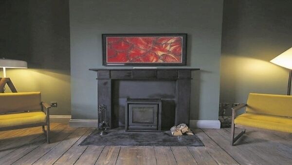 The ground-floor living room is painted in darker tones for a cosy feel and features one of the fireplaces reclaimed from the bedrooms. The ground-floor living room is painted in darker tones for a cosy feel and features one of the fireplaces reclaimed from the bedrooms.