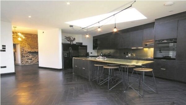 The kitchen extension added to the basement overlooks a garden, while internally the exposed brick links it to the original structure. The kitchen extension added to the basement overlooks a garden, while internally the exposed brick links it to the original structure.