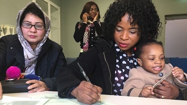 Gulnaz Aaqif Muhammad, left, with Deborah Oniah, right, and her daughter, Munachi, registering to vote at the Shape Your City voter registration event at the Cork Migrant Centre at Nano Nagle Place in Cork.