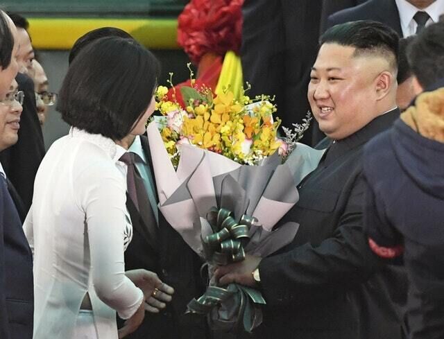 North Korean leader Kim Jong Un, right, receives bouquets on his arrival (Minoru Iwasaki/Kyodo/AP)