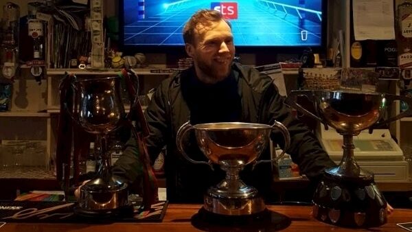 Brendan Kealy, barman and Kilcummin captain in Galvin's with the All-Ireland cup along with the Kerry and Munster cups.