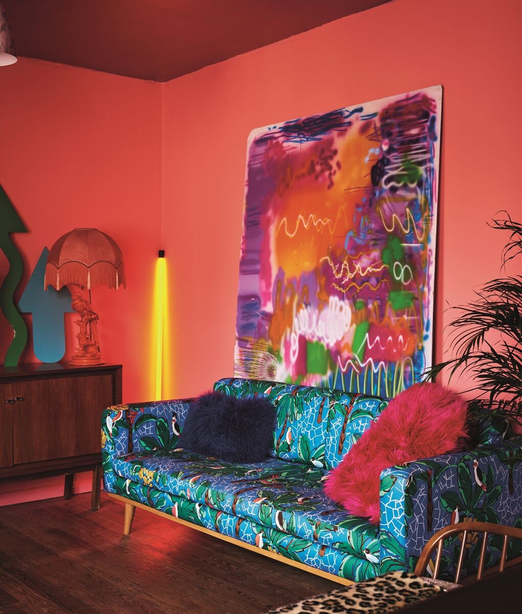 A tropical print sofa by Swoon, lights similar to Seletti, and canvas print from a local junk shop, as shown in Be Bold: Interiors for the Brave of Heart, by Emily Henson.